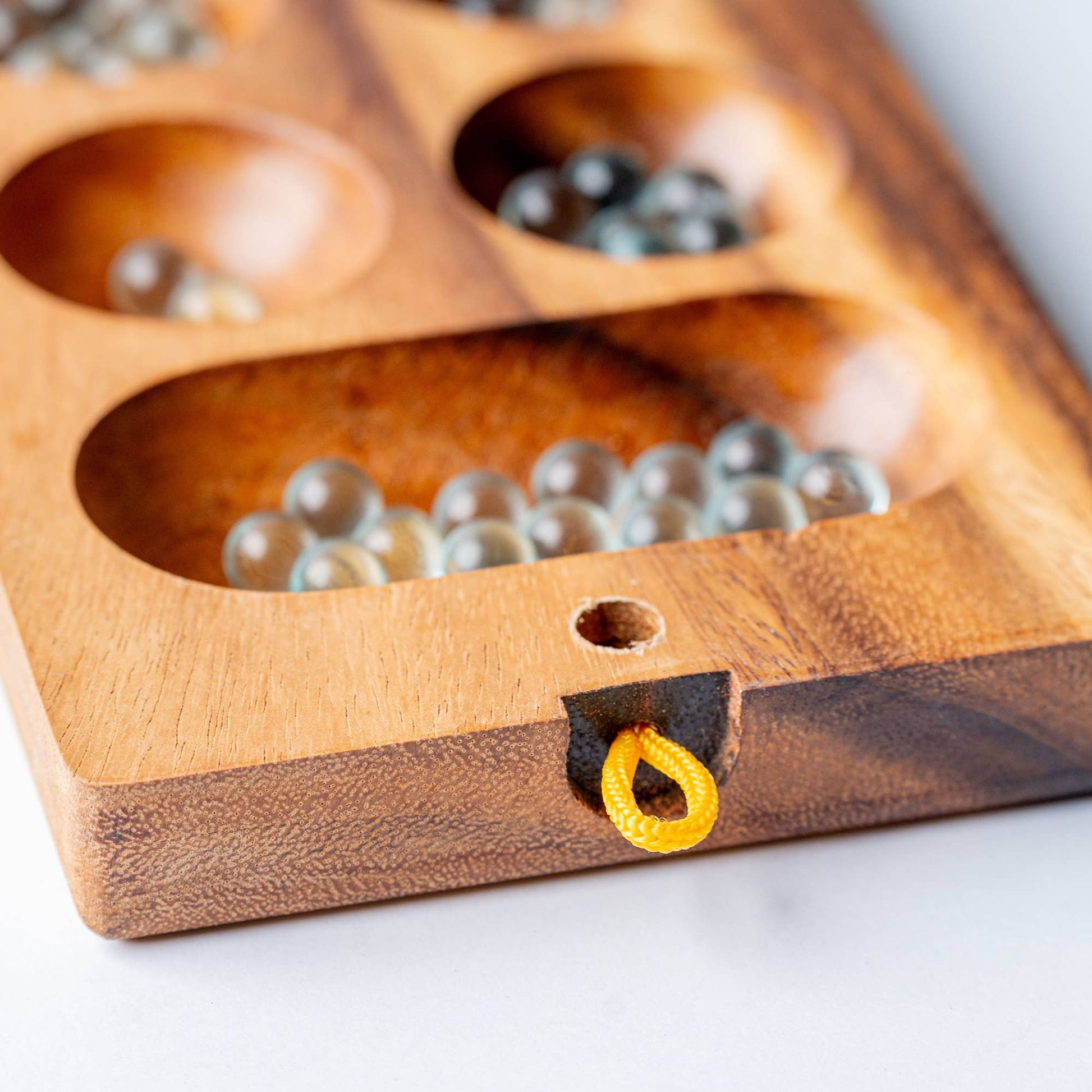 Wooden game board with beads on a white surface