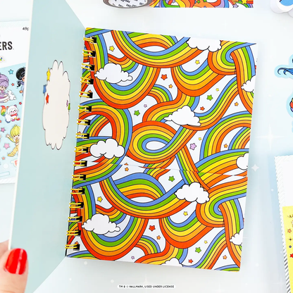 Colorful notebook with rainbow pattern held open by a hand.