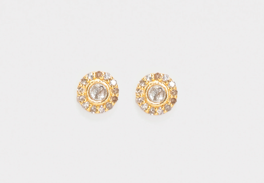 Pair of gold earrings with clear stones on a light gray background
