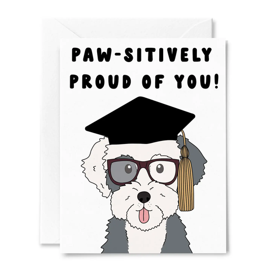 Greeting card with a dog wearing a graduation cap and tassel, and text 'PAW-SITIVELY PROUD OF YOU!' on a white background.