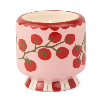 Ceramic candle container with tomato design on a white background