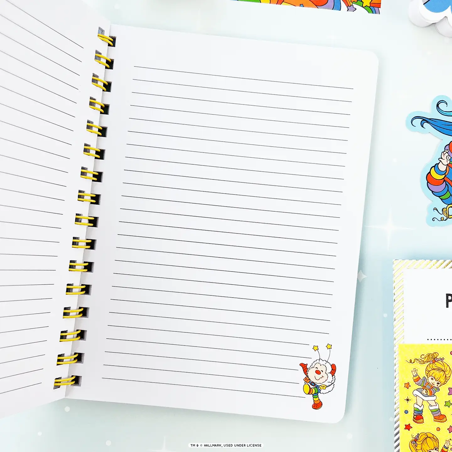 Notebook with lined pages and colorful cartoon character on a white background
