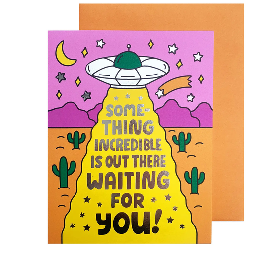 Card with UFO design and text 'Something incredible is out there waiting for you!' on a desert background.